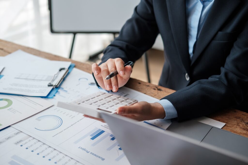 Accountant using calculator for calculate finance report in office.